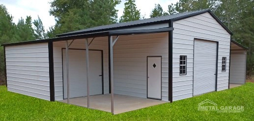 A small metal shed with a covered carport on a grassy area.