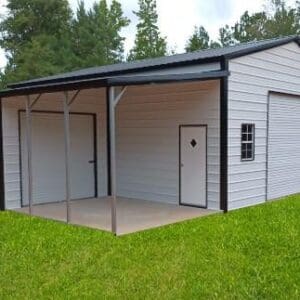 Metal barn with garage in grassy area.