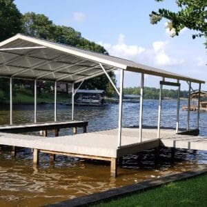 Lakeside dock with covered structure and trees.