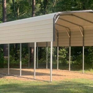 Metal carport structure in a wooded area.