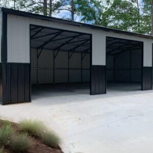 Metal garage with open doors and driveway.
