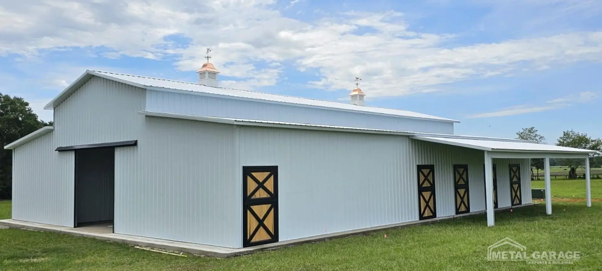 White metal barn with multiple doors.